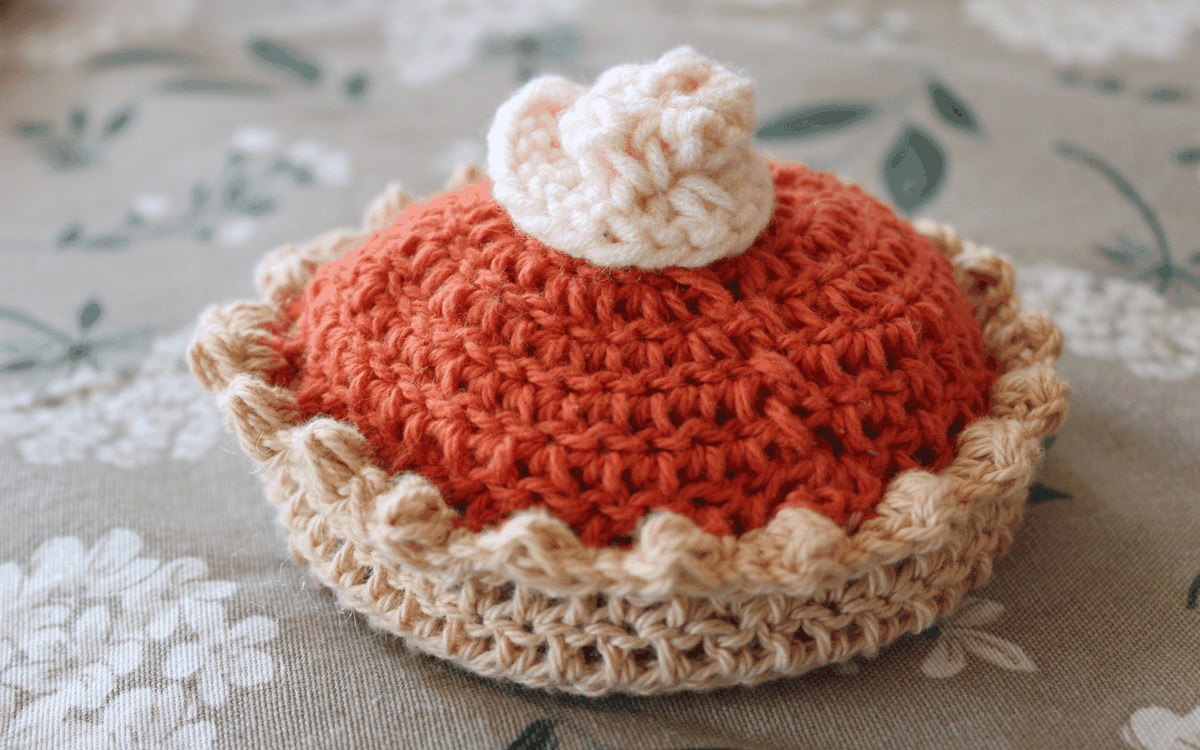 Crocheted slice-sized pumpkin pie with whipped cream